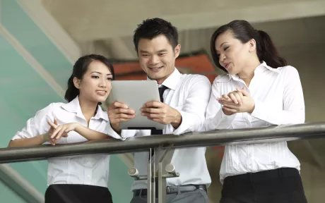 Three persons looking at iPad